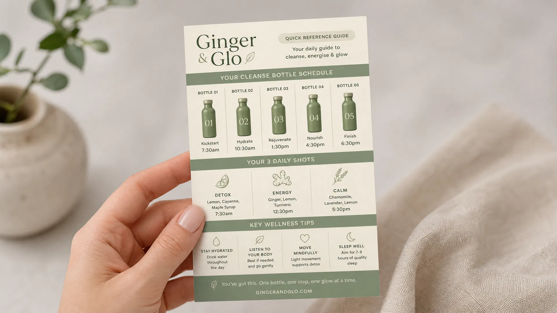 "Mockup of the Ginger & Glo quick reference guide A6 card held in hand, showing the cleanse bottle schedule, daily shots, and key tips in a compact, easy-to-read format"